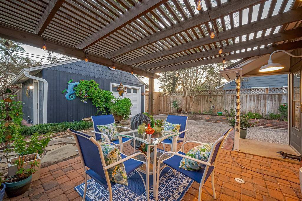 View from the primary French doors to the pergola. You can see the  oversized garage in the background, which is perfect as a guest house!