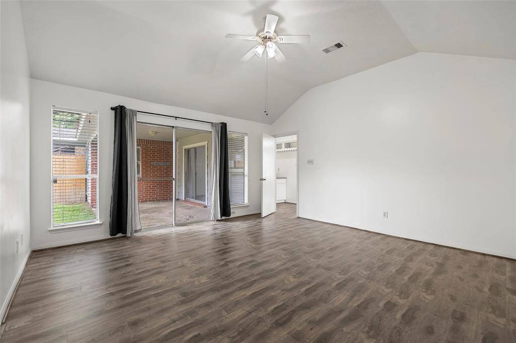 Primary bedroom with new wood flooring and access to the back covered patio.