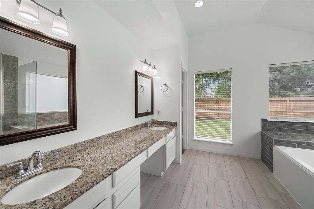 Primary bathroom with dual sinks, granite countertops and dual walk-in closets.