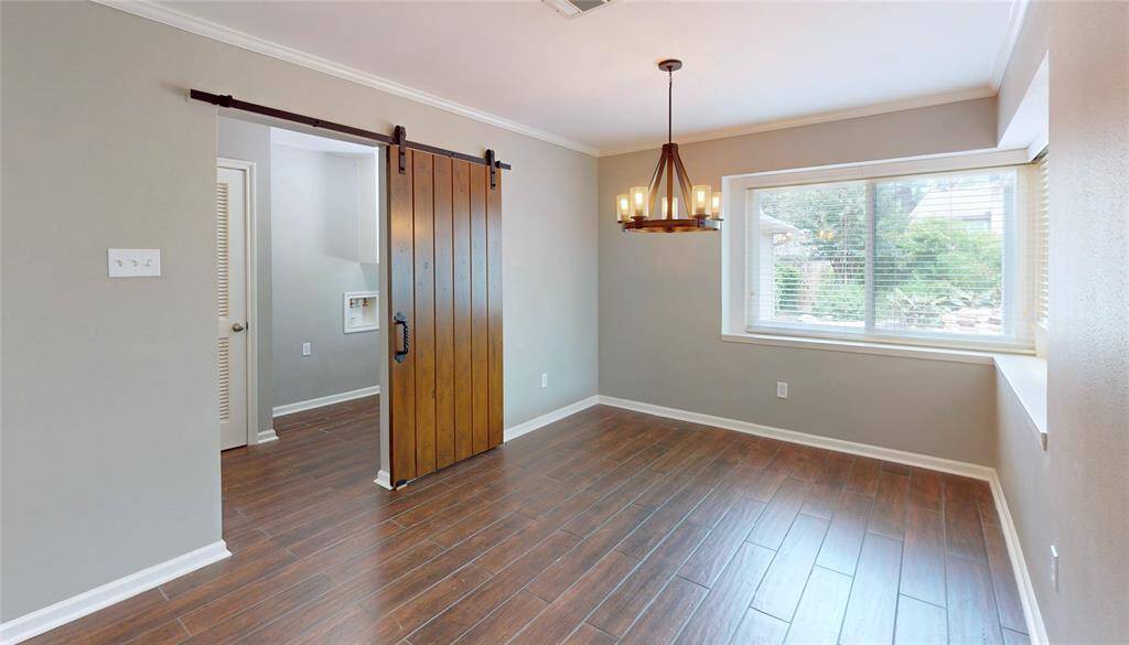 The breakfast is off the kitchen and has been updated with a new lighting fixture and sliding barn door that lead to the utility room.