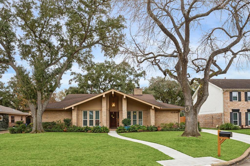The large front yard is enhanced by mature trees and establishedtropical landscaping.