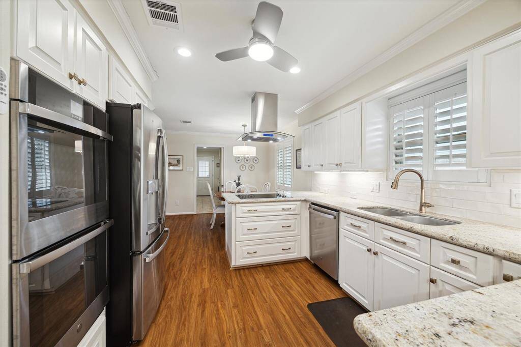 The updated kitchen includes stainless steel appliances: double ovens,microwave, refrigerator, cooktop, dishwasher, and attractive island venthood.