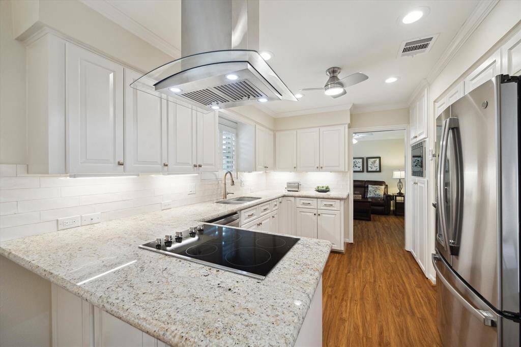 The warm and inviting kitchen has updated “white” granite with aSpanish subway tile backsplash, soft-close doors/drawers, pull-out pantry,and Lazy Susan.