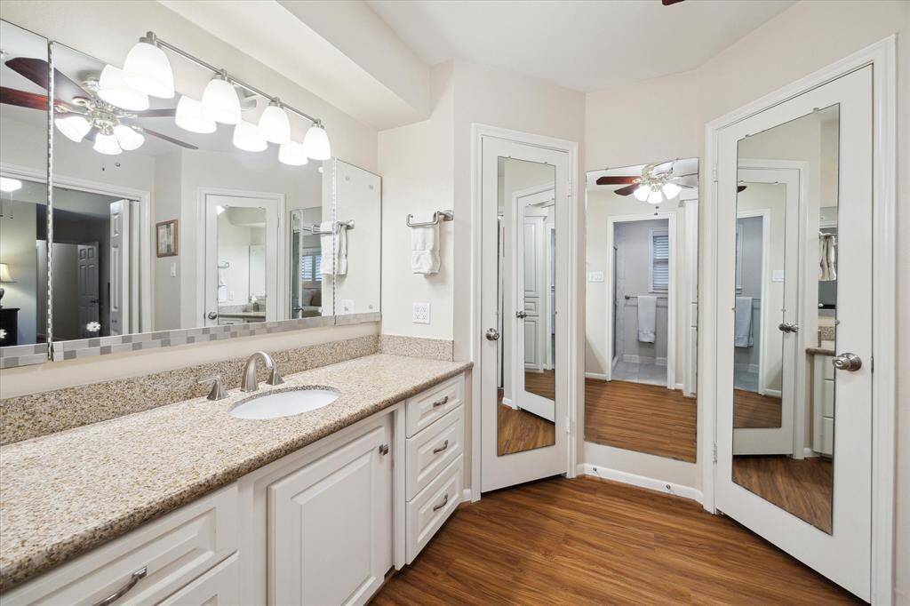 A mirrored dressing area is conveniently located outside of the largewalk-in closet with a built-in chest of drawers.