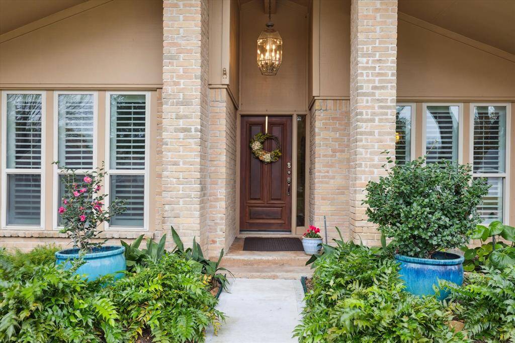 The well-covered entry is highlighted by a beautiful wood door anddramatic chandelier.