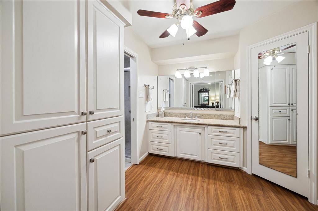 The primary bath has plenty of extra storage and a large vanity. Thearea is cooled by a ceiling fan.