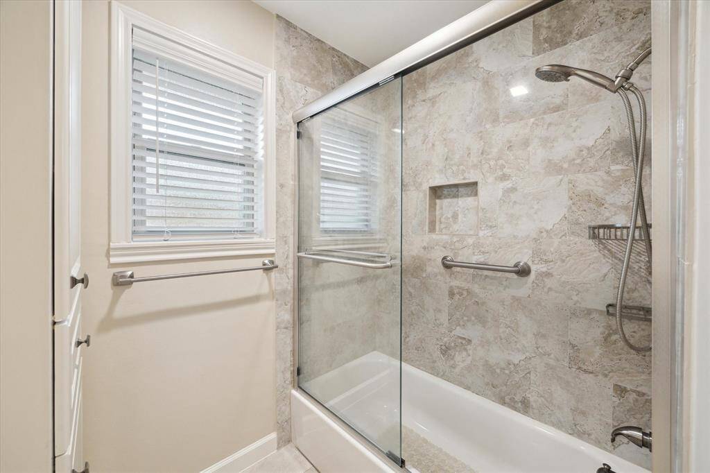 The updated tub/shower has clear glass sliding shower doors.
