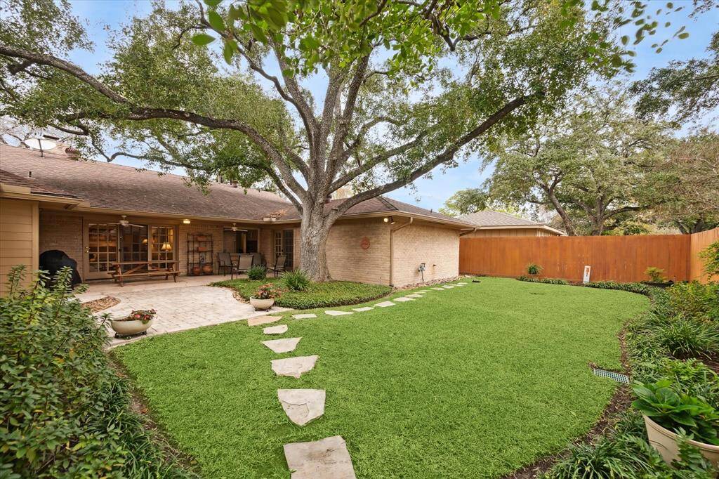 The lovely backyard includes a large, covered patio with paversextending into the yard. The stained fence provides an attractive backdropfor the garden beds.