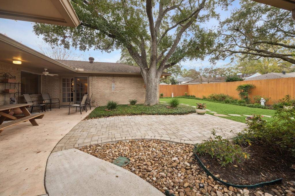 The lovely backyard includes a large, covered patio with paversextending into the yard. The stained fence provides an attractive backdropfor the garden beds.
