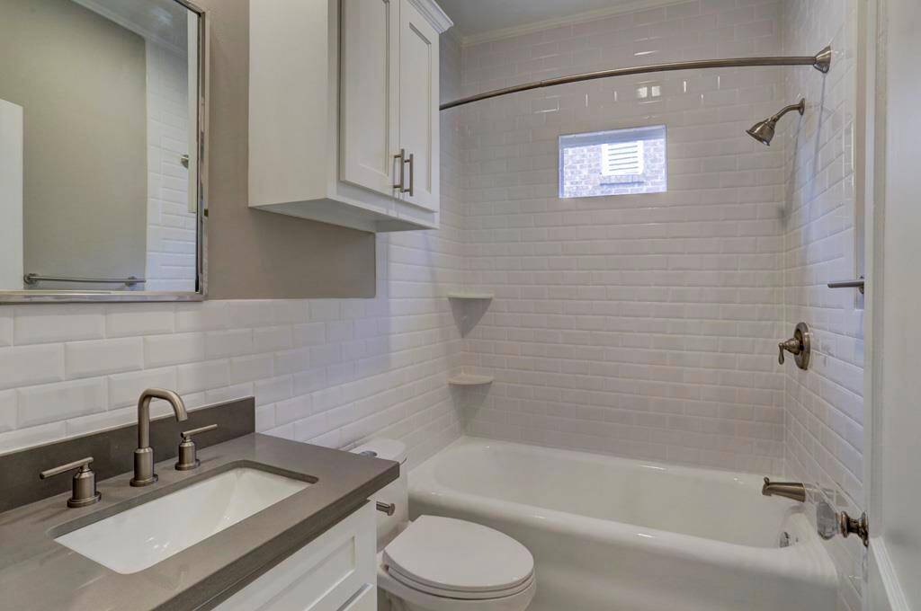 Newly renovated bathroom with beveled subway tile surround, stone counter top, single piece toilet with soft close lid.  New tankless hot water heater provides endless hot water!
