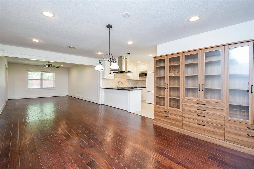 Beautiful, high-quality wood flooring flows seamlessly through the living, dining, and hallway spaces.