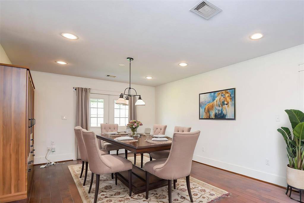 Virtually staged dining area with a view of the kitchen and French doors leading outside—perfect for entertaining.