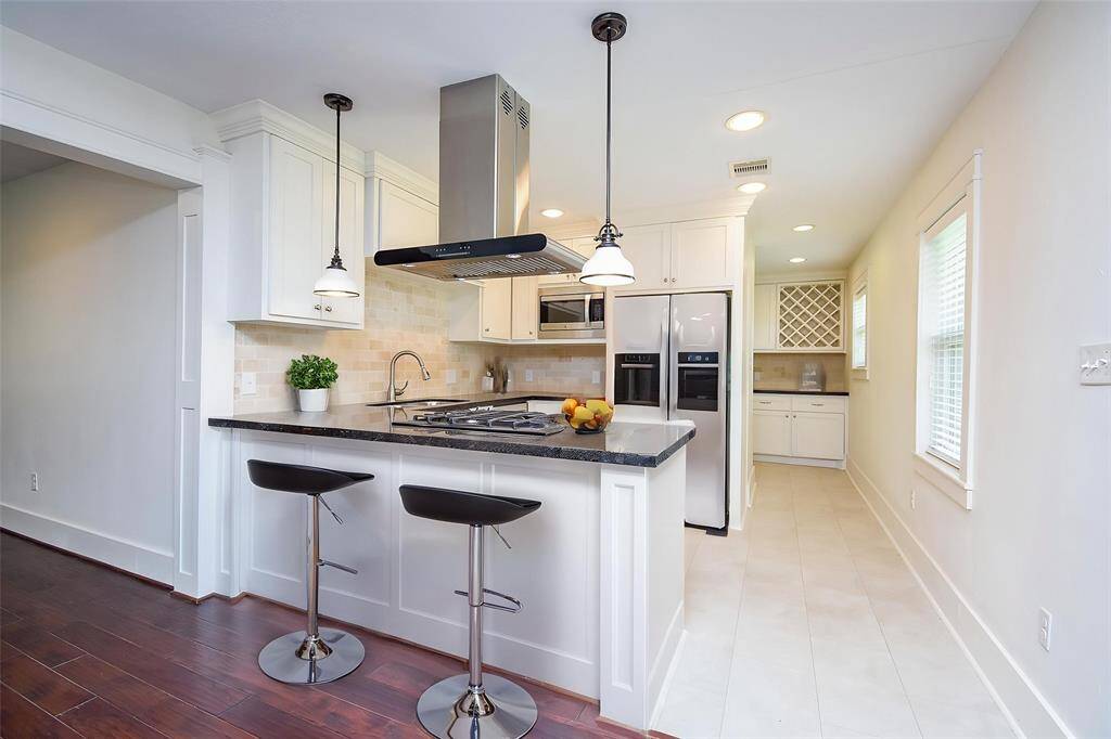 Chic and functional breakfast bar enhances the open-concept layout between kitchen and dining.