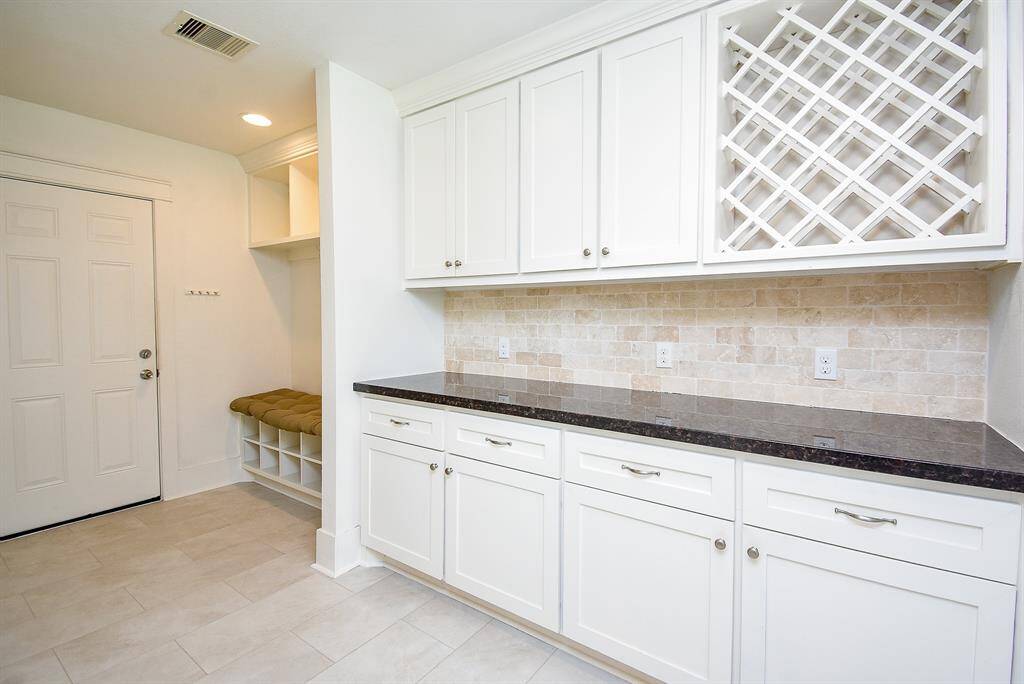 Spacious and convenient butler’s pantry featuring ample storage and a built-in wine rack.
