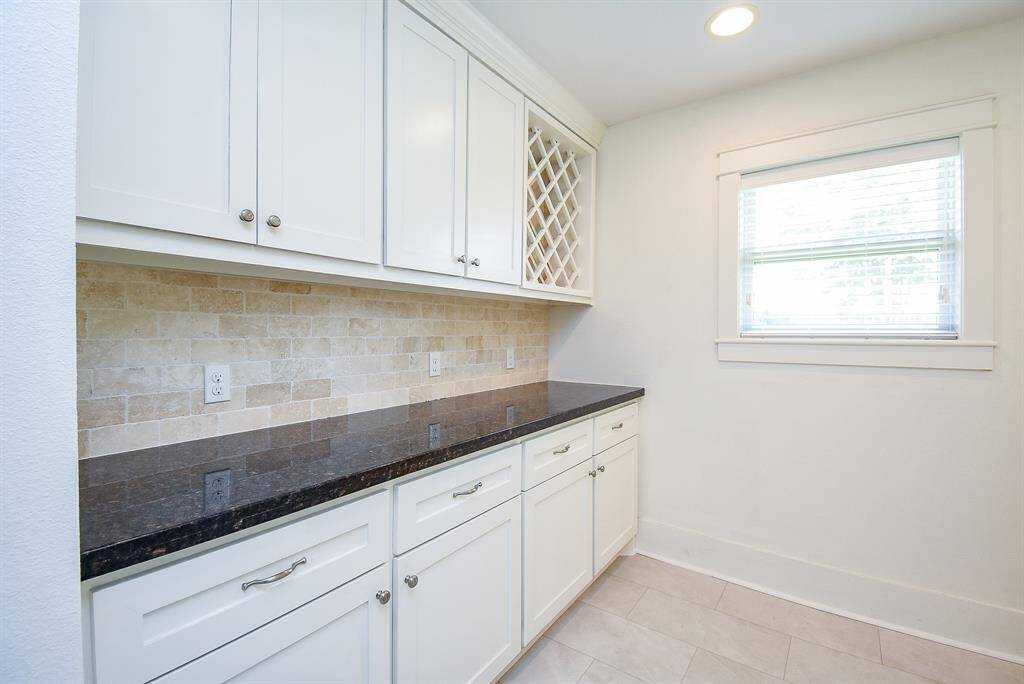 Spacious and convenient butler’s pantry featuring ample storage and a built-in wine rack.