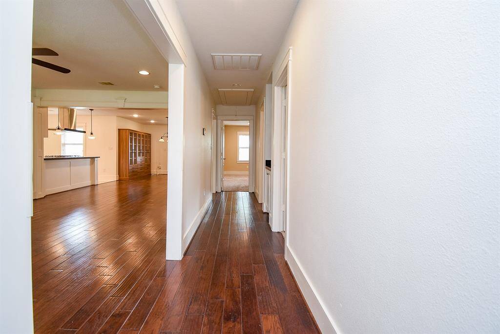 Beautiful, high-quality wood flooring flows seamlessly through the living, dining, and hallway spaces.