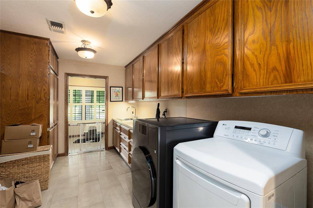 Very spacious Laundry Room, with tons of cabinets and a sink to wash your hands.