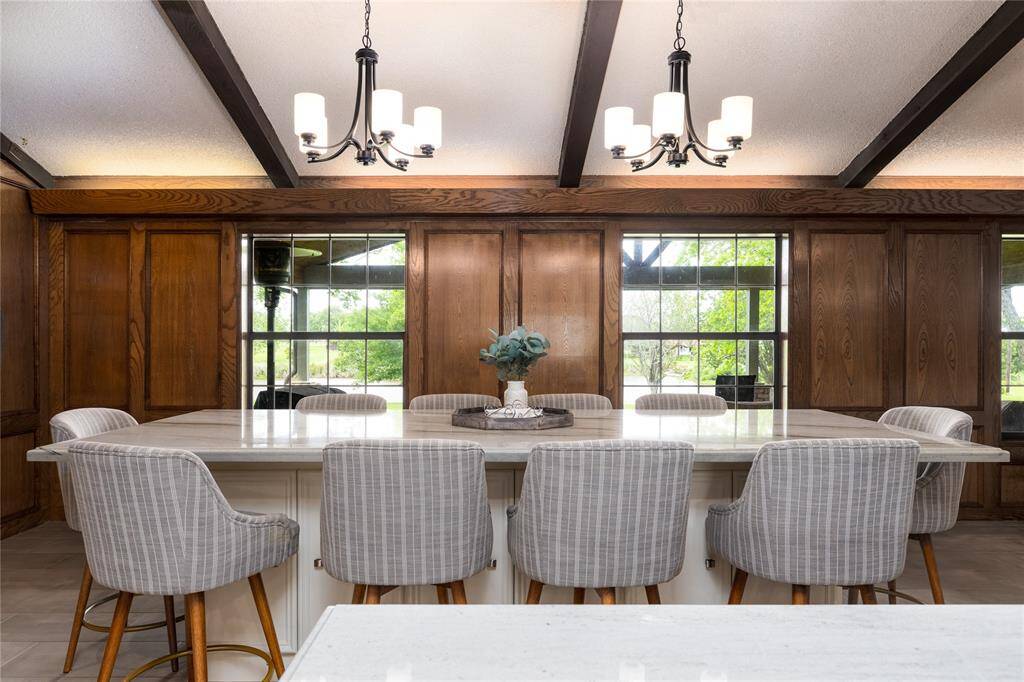 Large Island table with 10 chairs that stay with the home and it has a quartz table top.