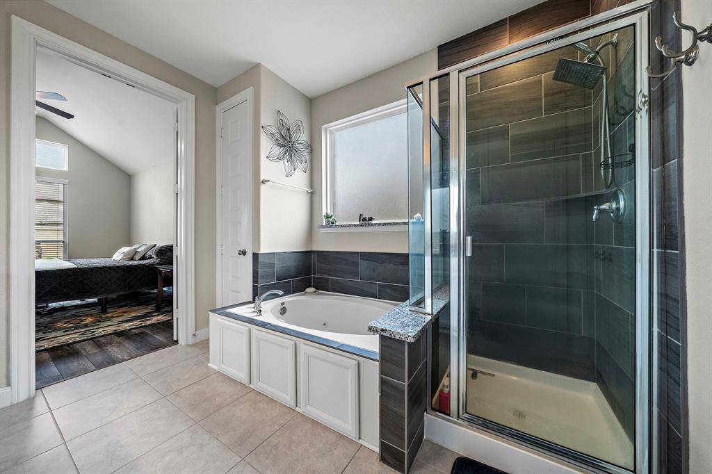Relax and recharge in the spa-like bathroom complete with a deep soaking tub and separate walk-in shower. A large frosted window brings in soft natural light while maintaining privacy for your daily retreat.