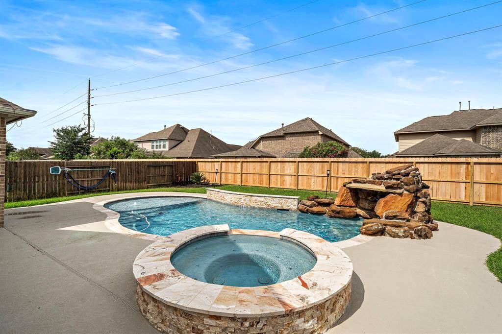 Relax to the sound of the cascading rock waterfall and enjoy the soothing atmosphere created by the thoughtfully designed poolscape. This backyard is perfectly suited for weekend lounging, summer parties, and everything in between.