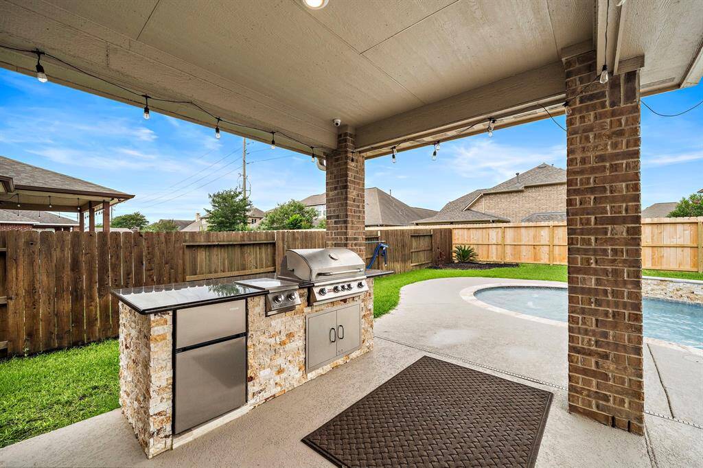 Host unforgettable evenings under the covered patio, equipped with a fully loaded outdoor kitchen and room for dining or lounging. With a view of the pool and spa, it’s an entertainer’s dream come true.