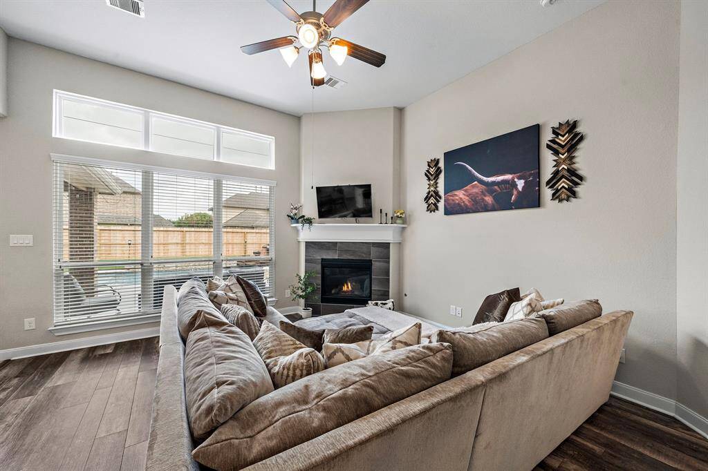 Positioned at the heart of the home, this living area offers a warm and welcoming space that connects effortlessly to the kitchen and upstairs. The elegant staircase and hallway arch add architectural interest while maintaining an open, functional flow.