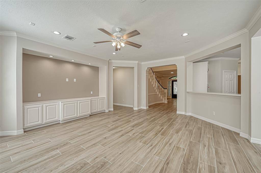 CUSTOM BUILT-IN CABINETS OFFER ADDITIONAL STORAGE AND PLENTY OF ROOM FOR A LARGE TV ABOVE.