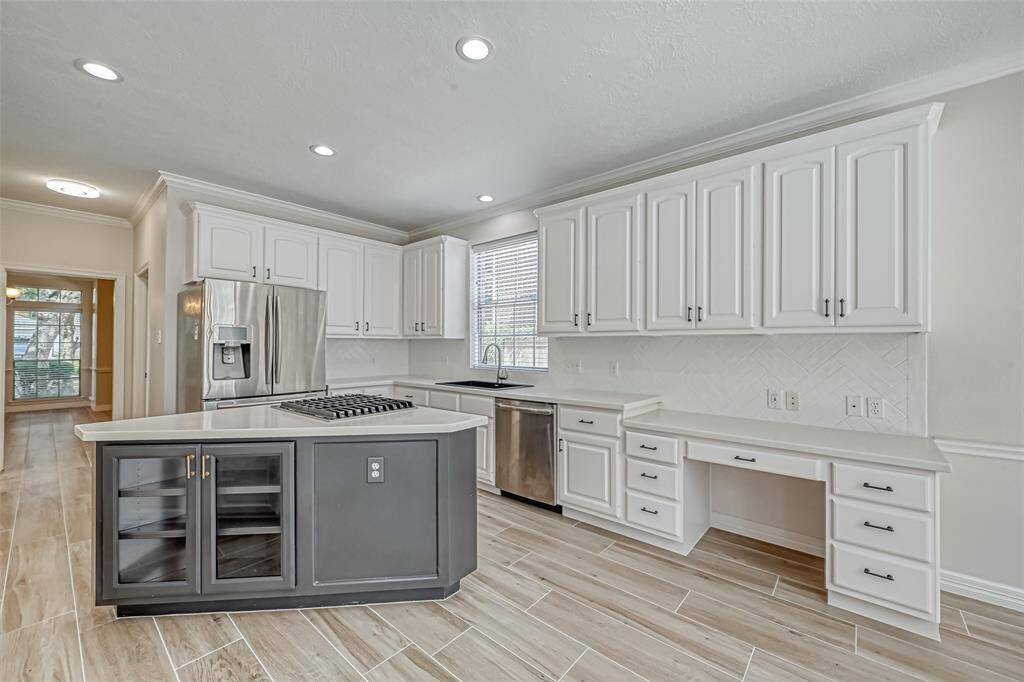 OPEN KITCHEN FEATURES A WIDE ISLAND WITH GAS COOKTOP.