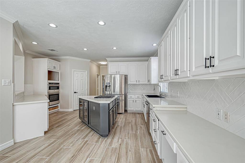 UPGRADED WITH STUNNING HERRINGBONE BACKSPLASH AND GLEAMING COUNTERS.
