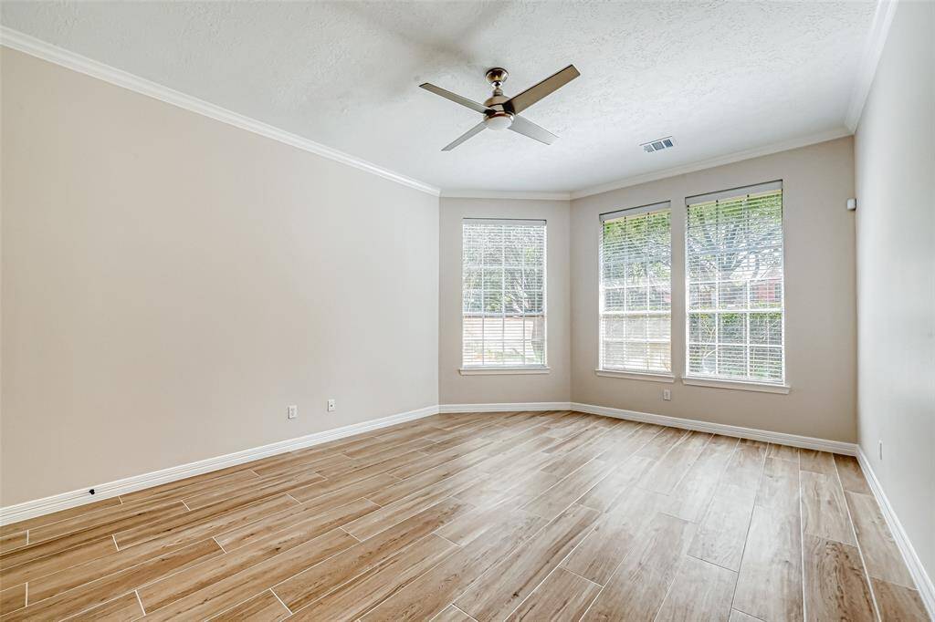 PRIMARY BEDROOM OFFERS A VIEW OF THE BACKYARD AND AN ENSUITE BATHROOM.