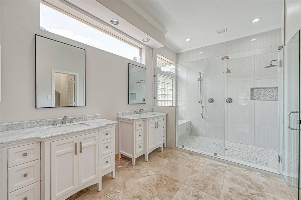 BEAUTIFULLY REMODELED SPA-LIKE PRIMARY BATHROOM OFFERS A HUGE WALK-IN SHOWER AND DOUBLE VANITIES.