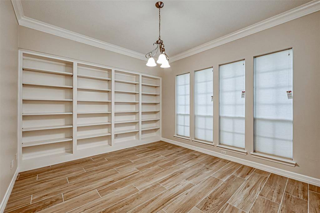 THE PRIVATE STUDY IS ON YOUR RIGHT WITH DOUBLE-FRENCH DOOR ENTRY AND A FULL WALL OF CUSTOM BOOKSHELVES.