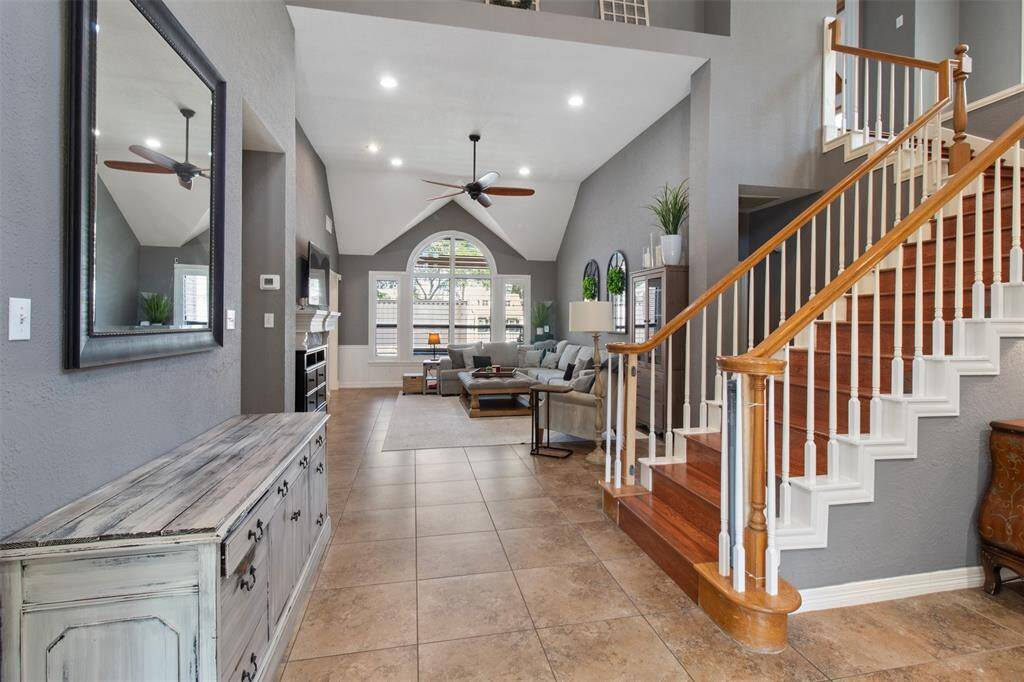 Upon entering, you're welcomed by a grand staircase and a spacious, open living room.