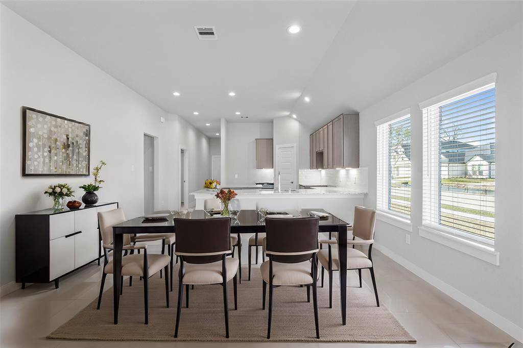 This lovely dining room is perfect for starting the day out on the right foot! This space showcases custom paint, high ceilings, recessed lighting, large windows adding to the ample natural light, and tile flooring!