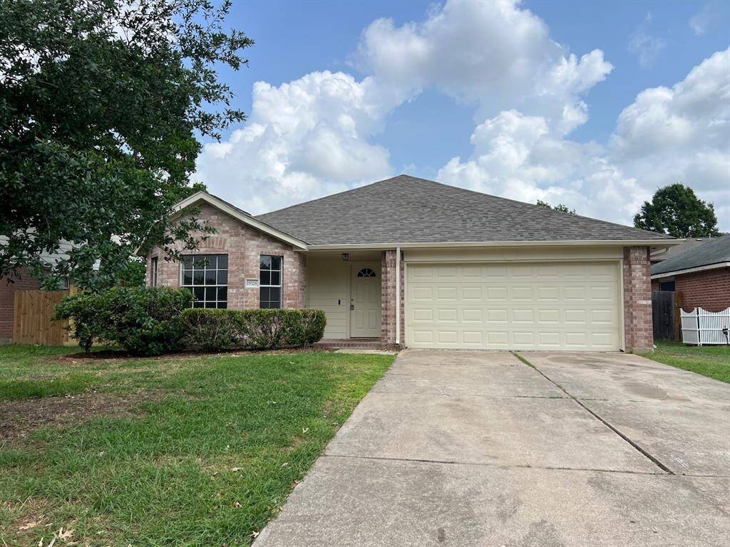 Charming single-story brick home with a two-car garage. It features a neat driveway and mature landscaping, offering a welcoming curb appeal.
