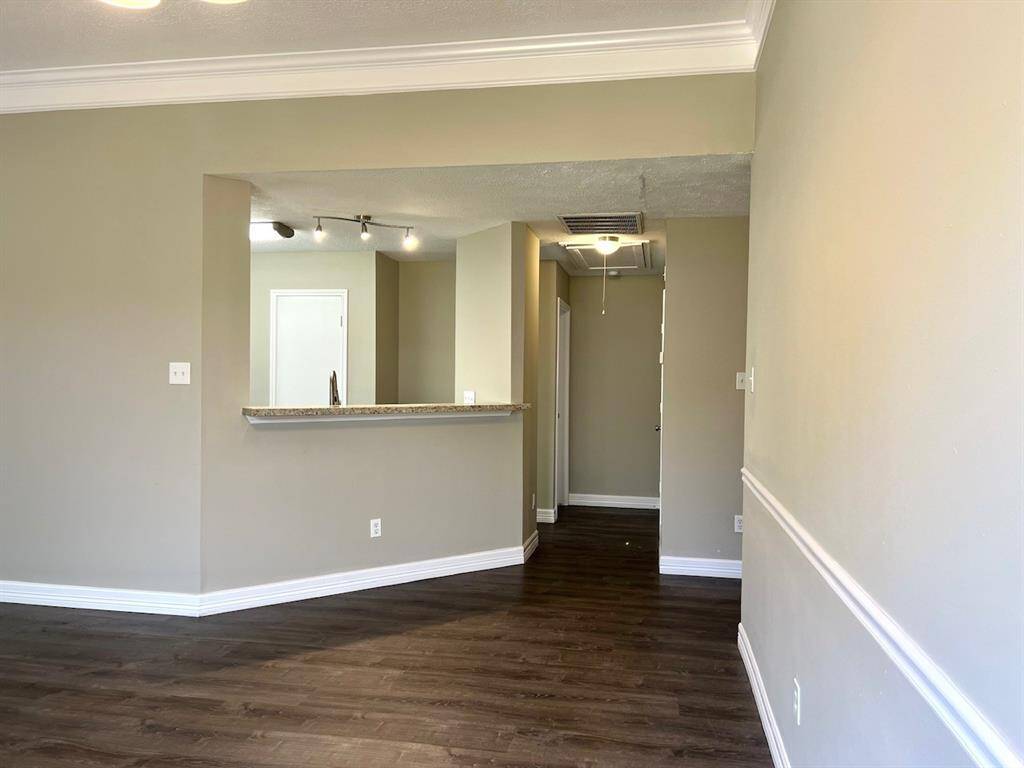 hallway next to kitchen leads to primary bedroom