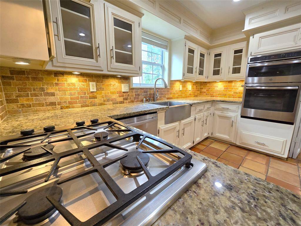 Redesigned kitchen with all the upgrades! Beautiful improved cabinetry, farm sink, brick backsplash, under cabinet mounted lighting, and just look at the mill work. WOW!!