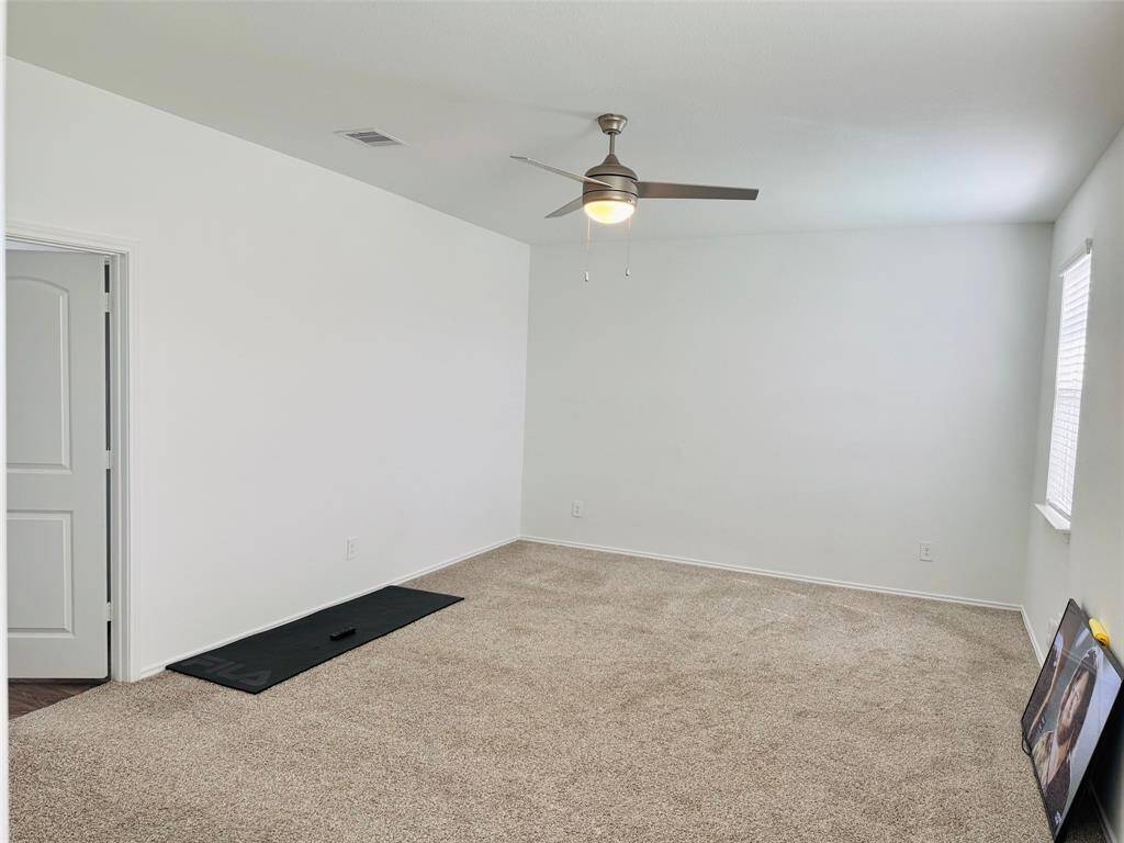 The primary bedroom has ceiling fan, and large window.
