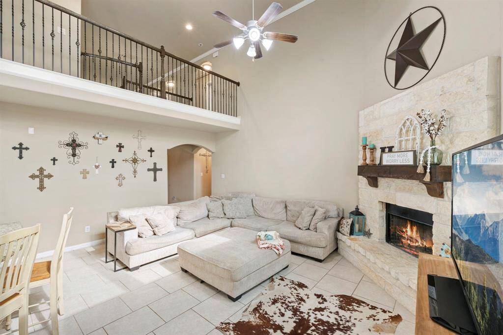 This charming two-story brick home features a welcoming front porch, well-maintained landscaping, and a spacious two-car garage, offering great curb appeal in a suburban setting.