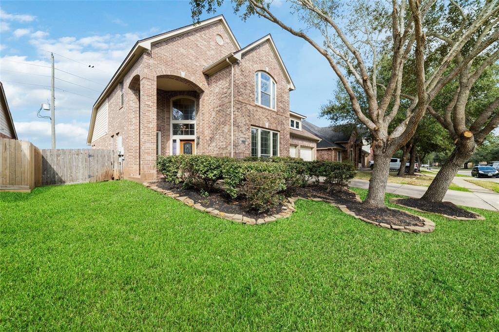 Welcome to 22026 Rustic Canyon. This charming two-story brick home features a well-maintained front yard with lush green grass and mature trees.