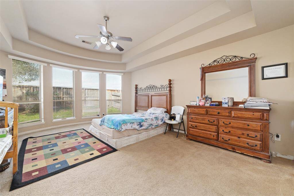 Over-sized primary suite with wall of bay window, crown-molding makes it an idea retreat place for the homeowners.