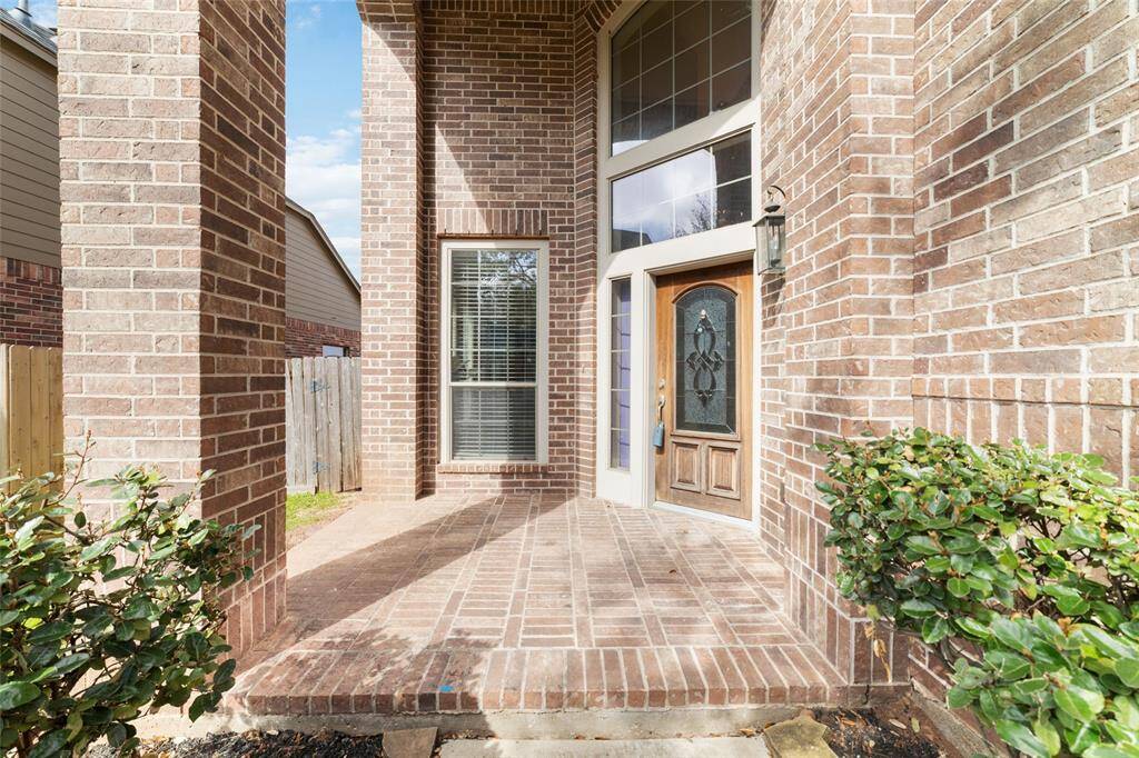 The entrance has a welcoming arched porch, perfect for those seeking a comfortable suburban living space.