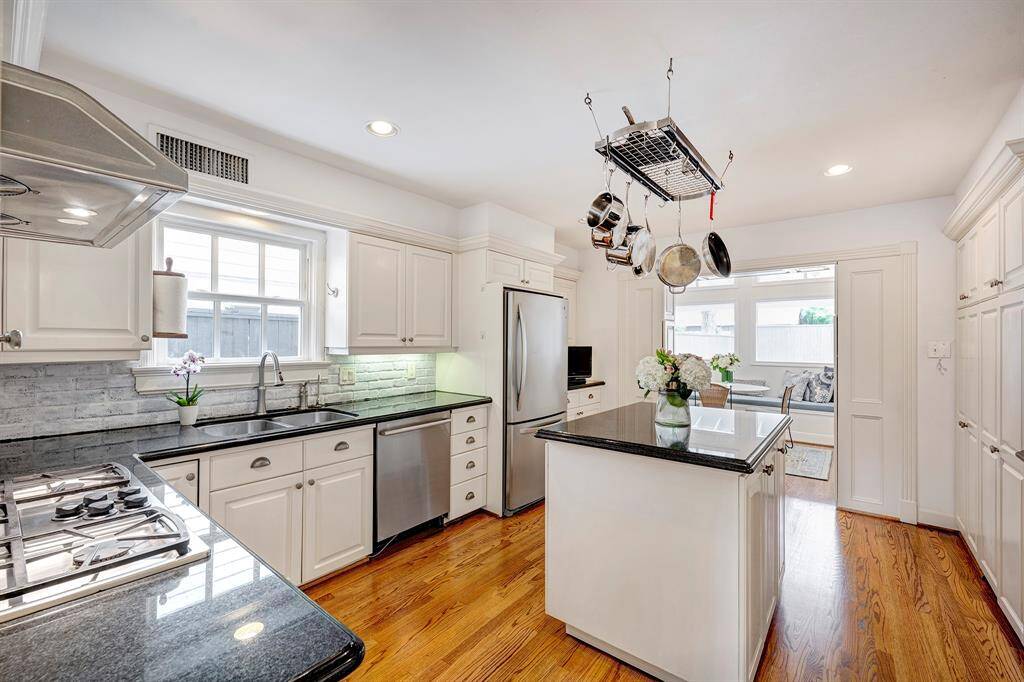 This vista of the kitchen highlights the abundance of natural light not only in this space but also throughout this impressive residence. The refrigerator and pot rack will be included in the sale.
