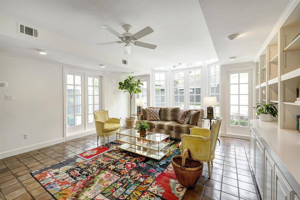 This expansive room features a wood burning fireplace, a wall of built-ins plus many windows.