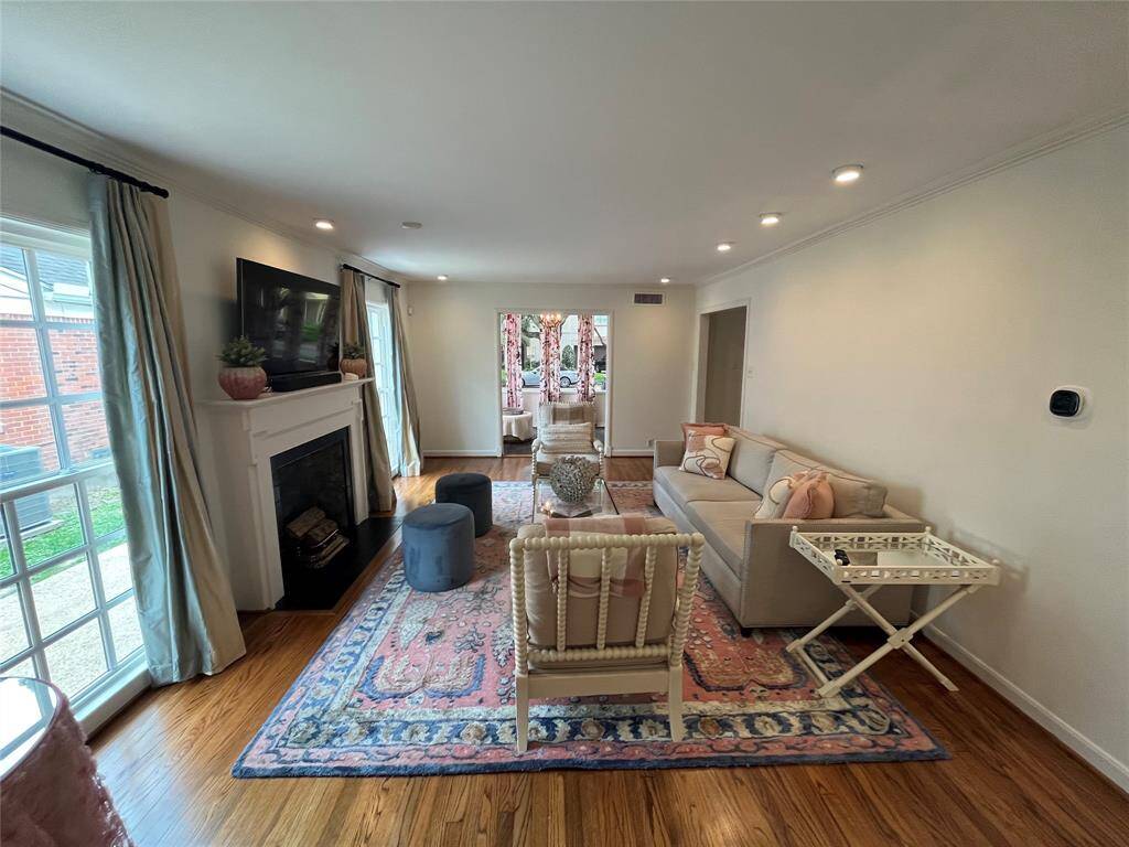 The lavish living room [18' x 13'] is bathed in natural light from two floor-to-ceiling windows offering eastern exposure. The red oak hardwood floors are newly refinished - April 2025 per Seller.