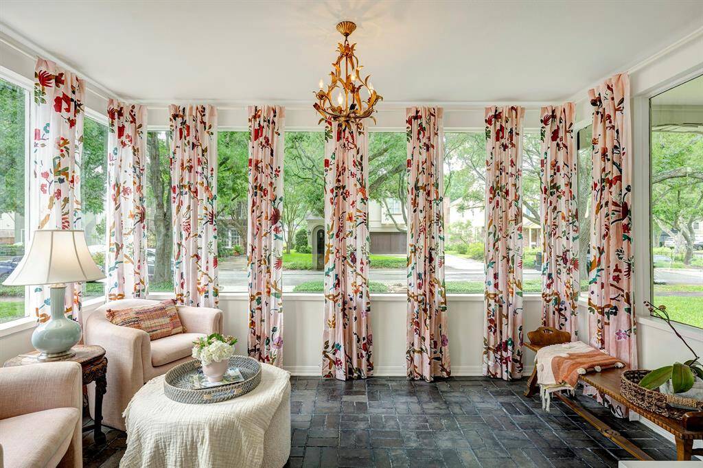 A stunning space! The current owners added the vibrant drapery panels which tastefully frame each window panel. Historically, the sun room has used it as a children's play room and most recently as a homework/art niche.