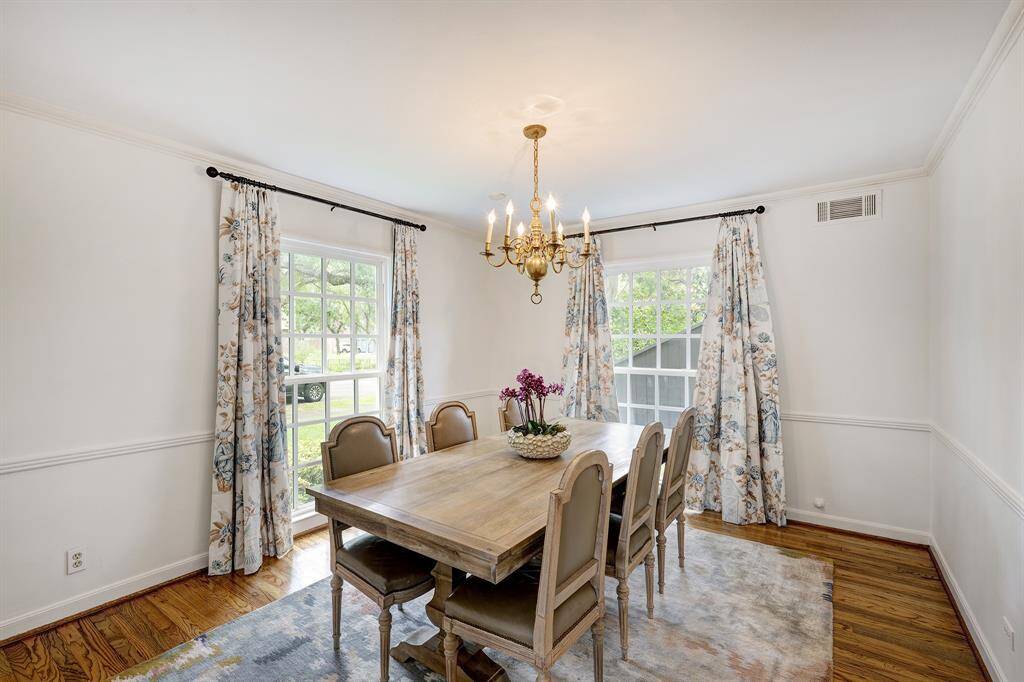 The formal dining room [13' x 12'] is situated on the southwest corner downstairs. The floor-to-ceiling windows, like many throughout this traditional home, are double pane. Notice the pretty millwok from the baseboards, to the 'chair rail' up to the crown molding where the wall meets the ceiling. Lovely!