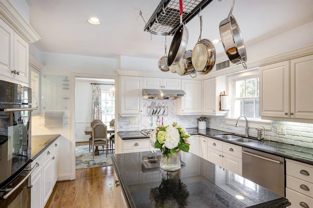 The great-looking granite/stainless kitchen [15' x 13'] features a gas cooktop, vent hood, double ovens, oversized island, numerous drawers for utensils plus a 'lazy Susan' cabinet in the lower SW corner.