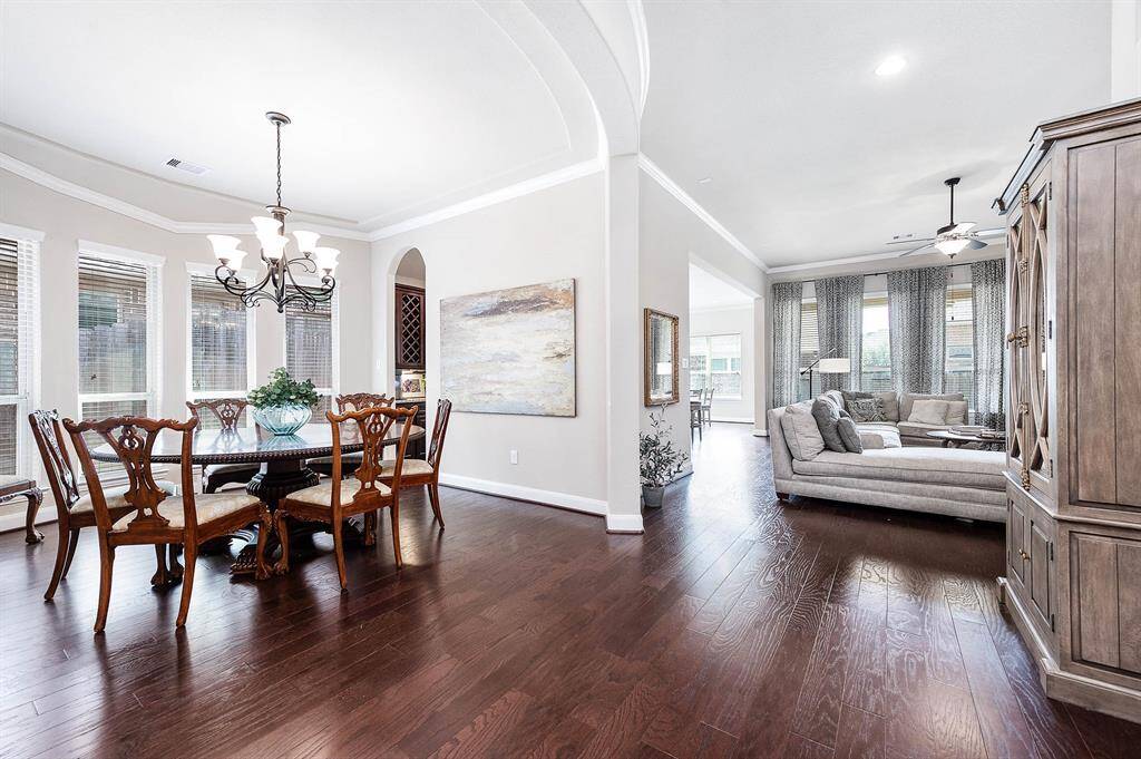 The formal dining room features ample natural light, vaulted ceilings with crown detail, and a walkthrough dry bar area with ease of access to the kitchen.