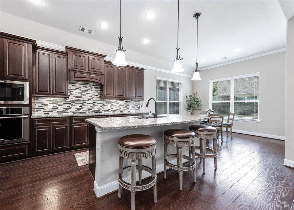 This beautiful kitchen features granite countertops, ample cabinet space, and SS appliances.